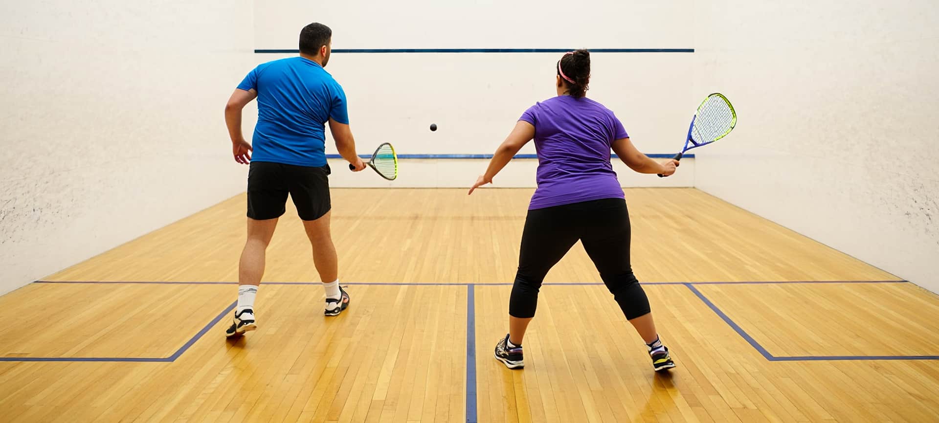 Man and woman playing racquetball on an indoor court at the Valley of The Sun YMCA